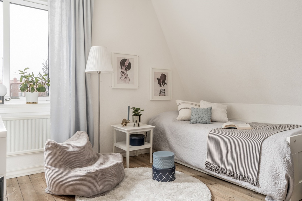 Sovrum med en enkelsäng och en sittpuff