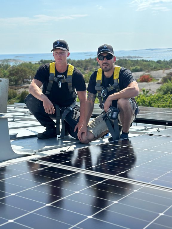 Två solcellsinstallatörer på ett solcellstak