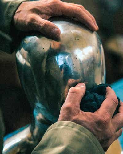 Två händer som håller i en skulptur