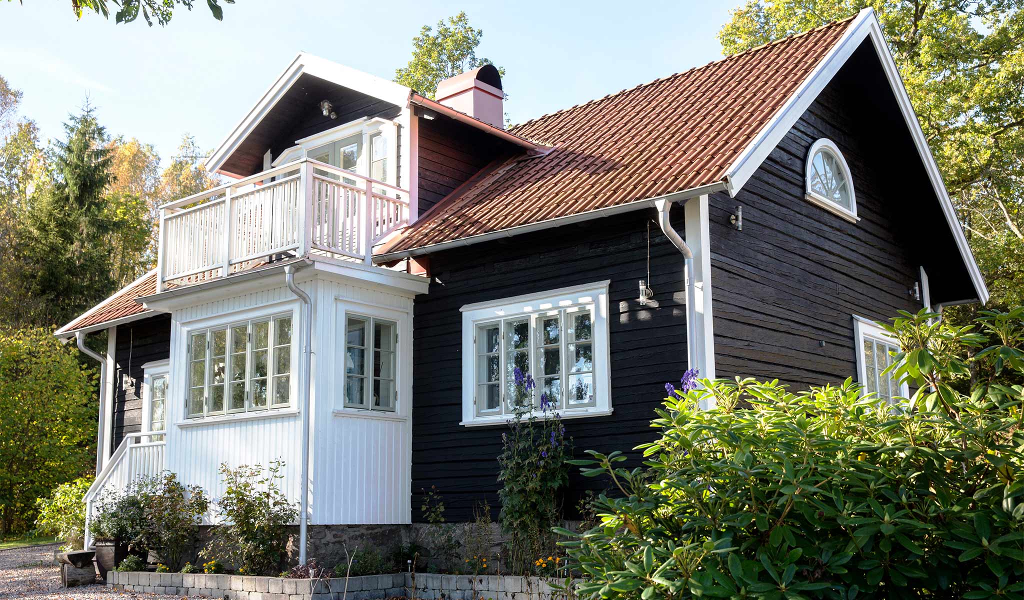 svart villa med balkong och farstu