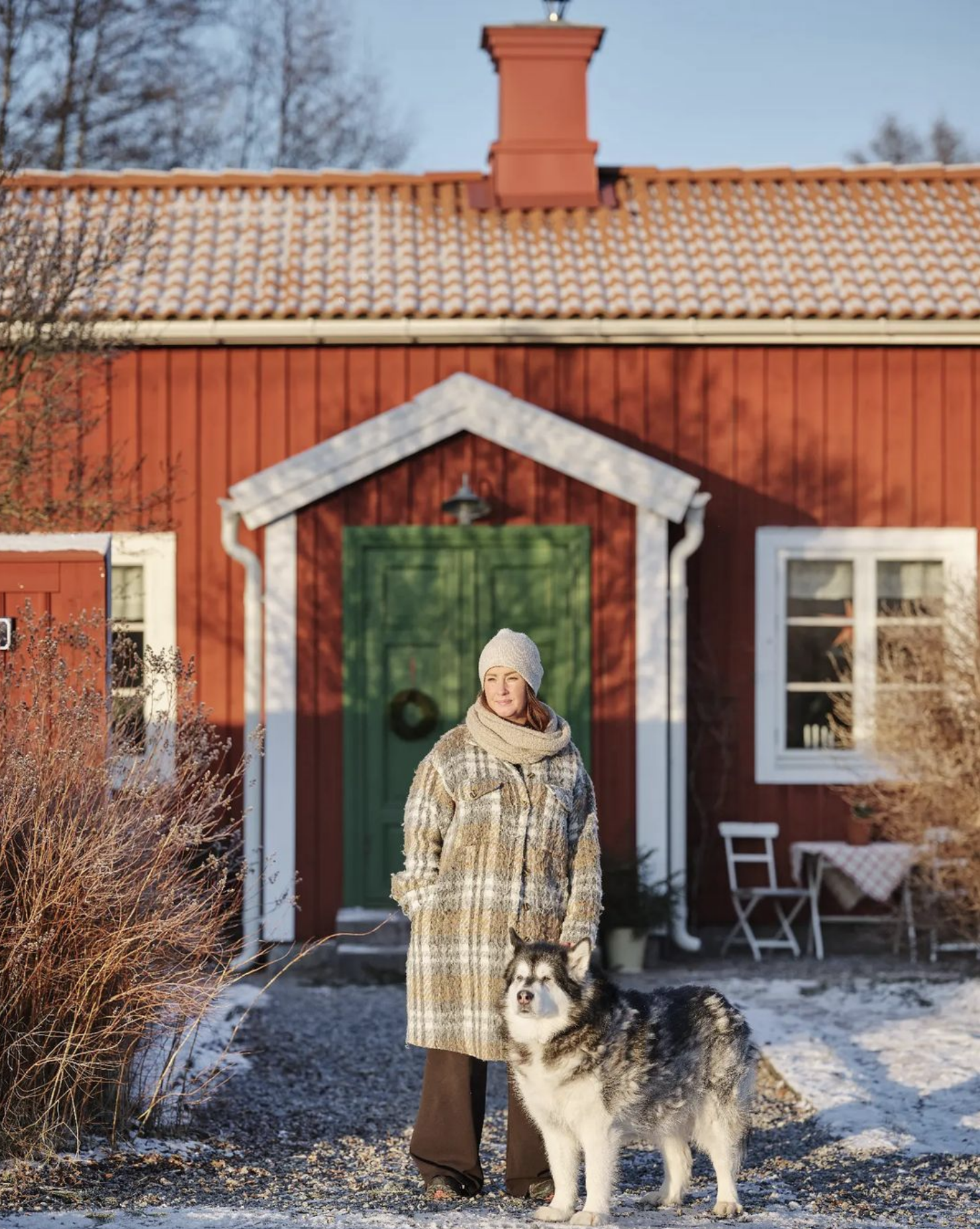Helena framför stugan med hund