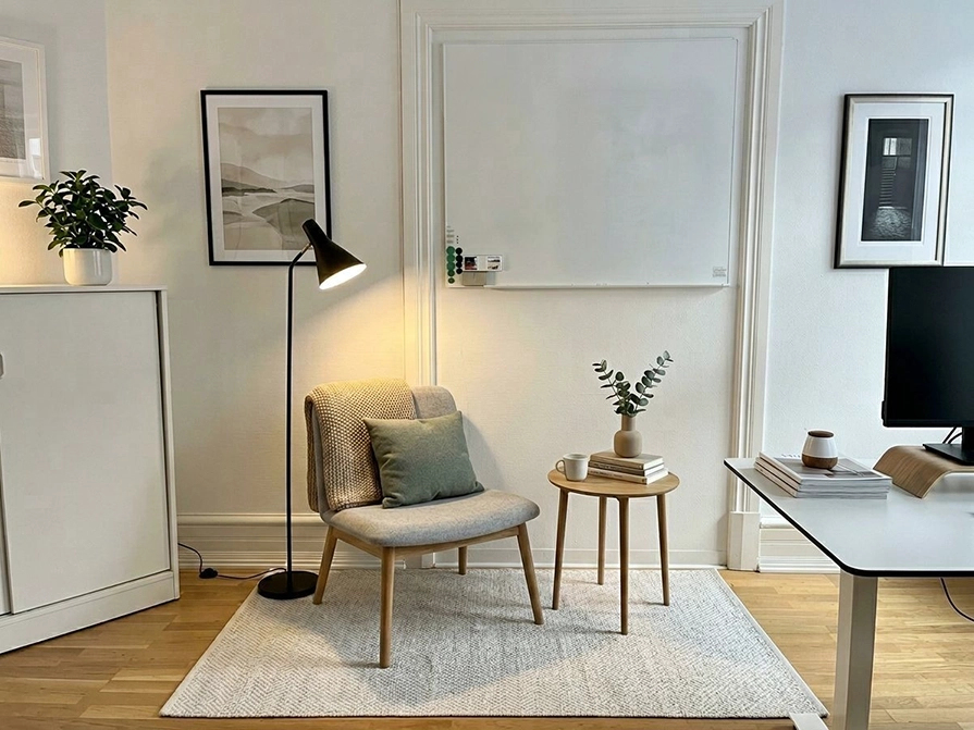 modern läshörna i ett kontor med skåp, fåtölj och ett litet bord