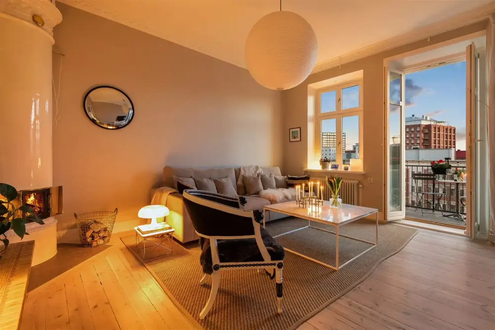 Vardagsrum med öppen spis och utgång mot balkong