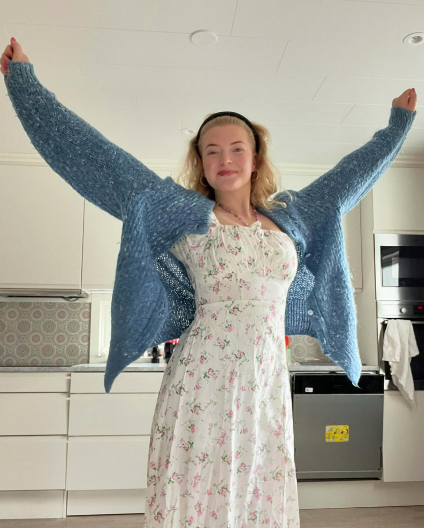 Wilma står i en klänning och sträcker upp armarna