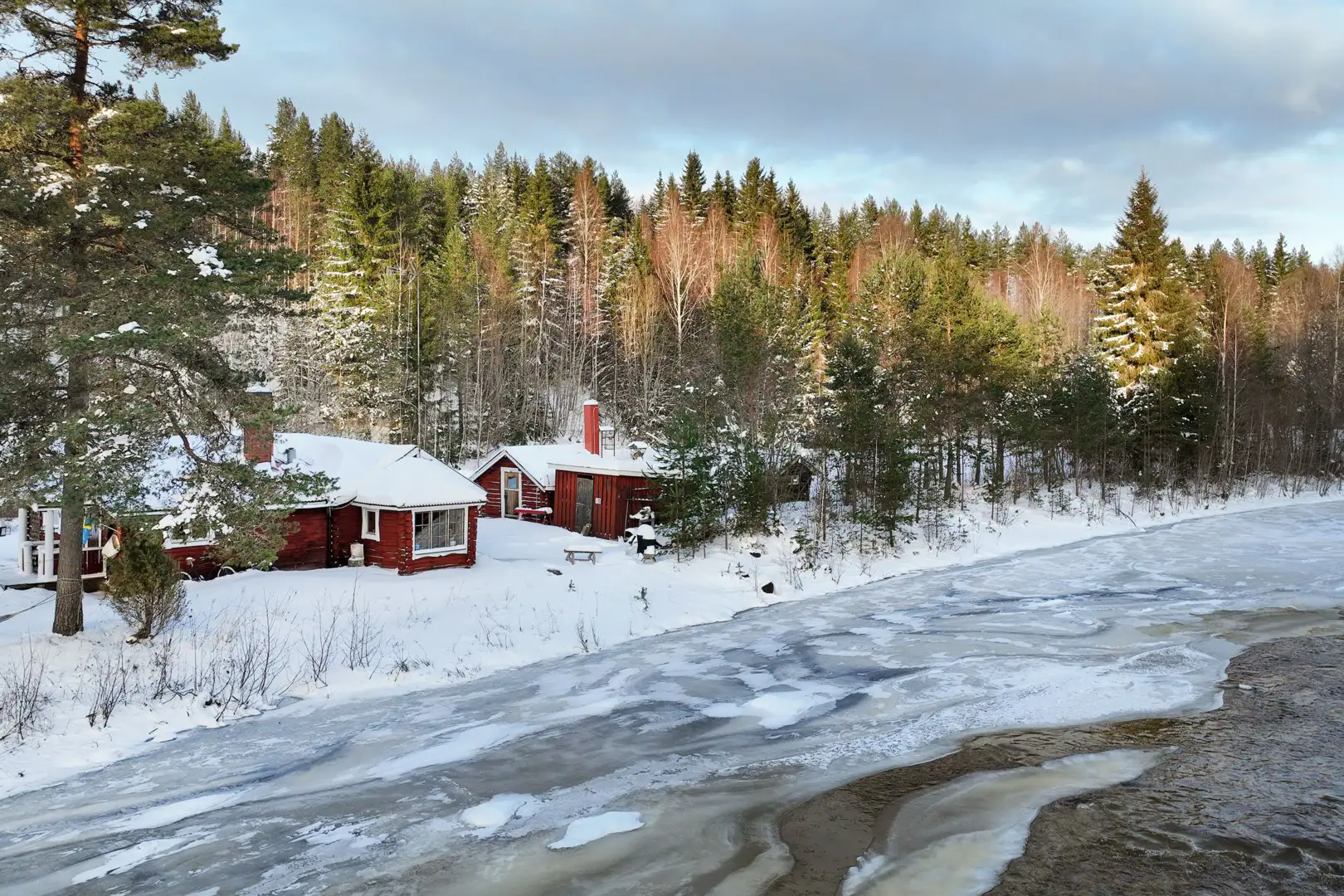 rött hus på strandtomt i dalarna