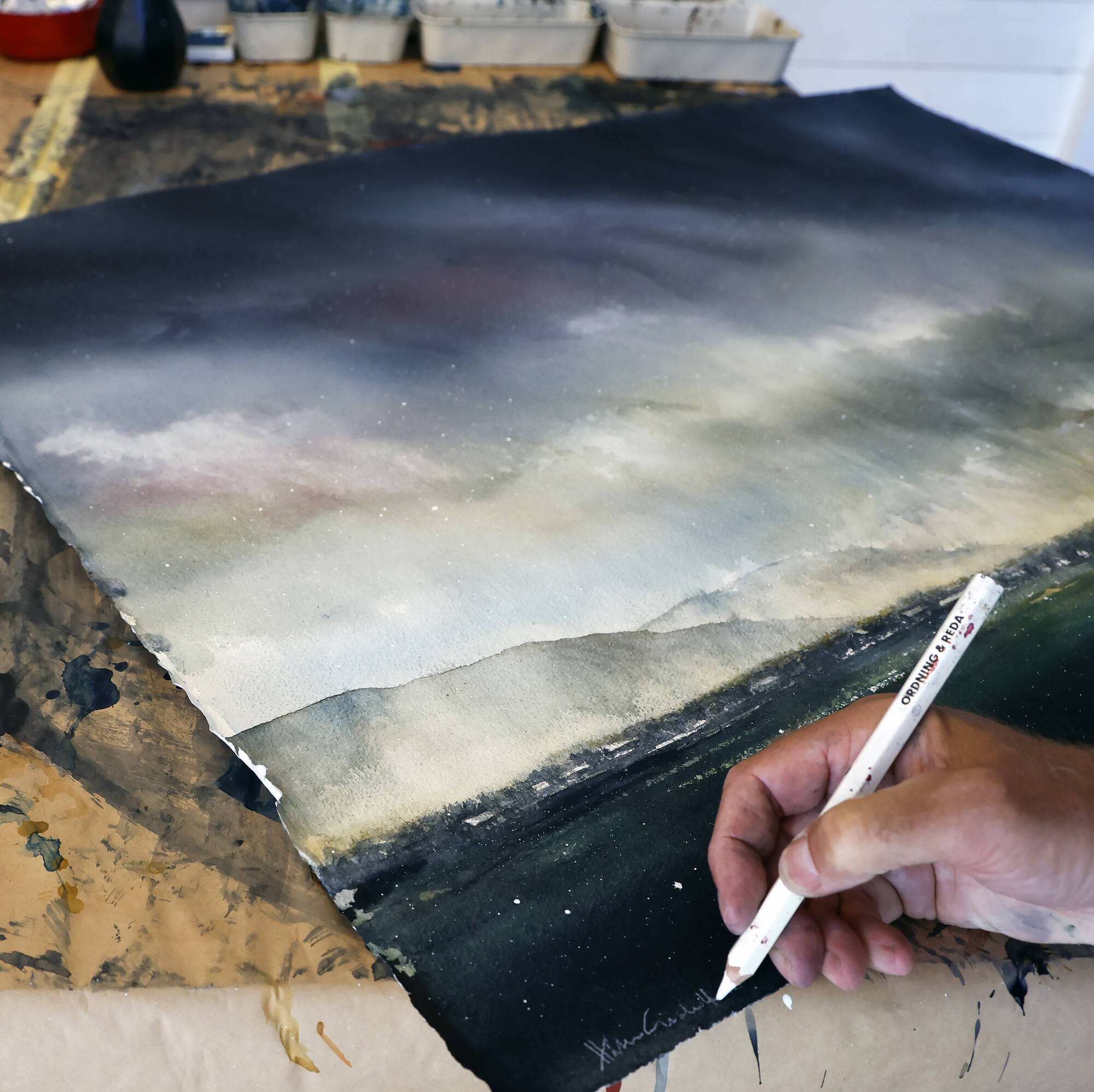 Konstnär Håkan Gidebratt signerar ett av sina dramatiska verk