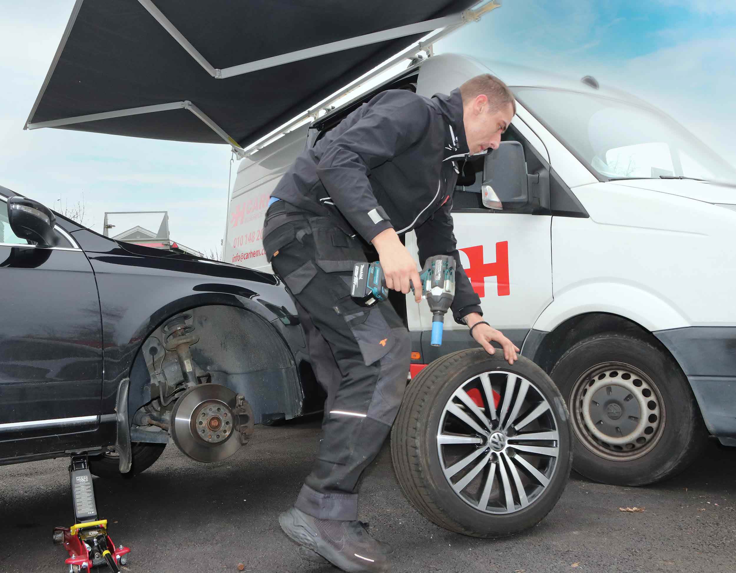person som byter däck, bilverkstad hem