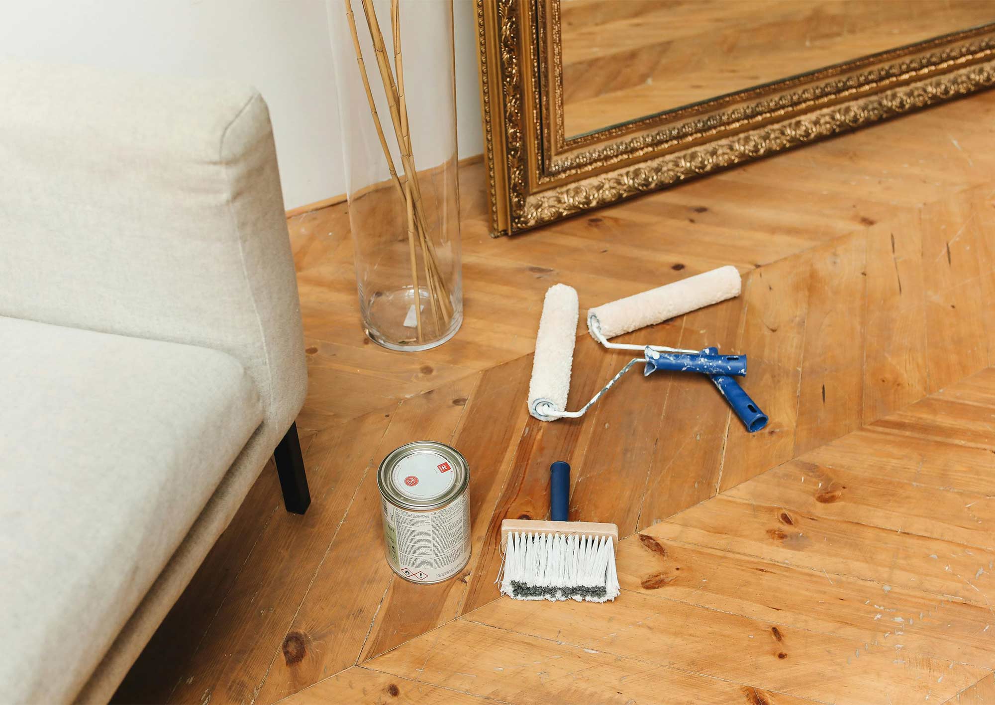 Målartillbehör på golv i gammal lägenhet.