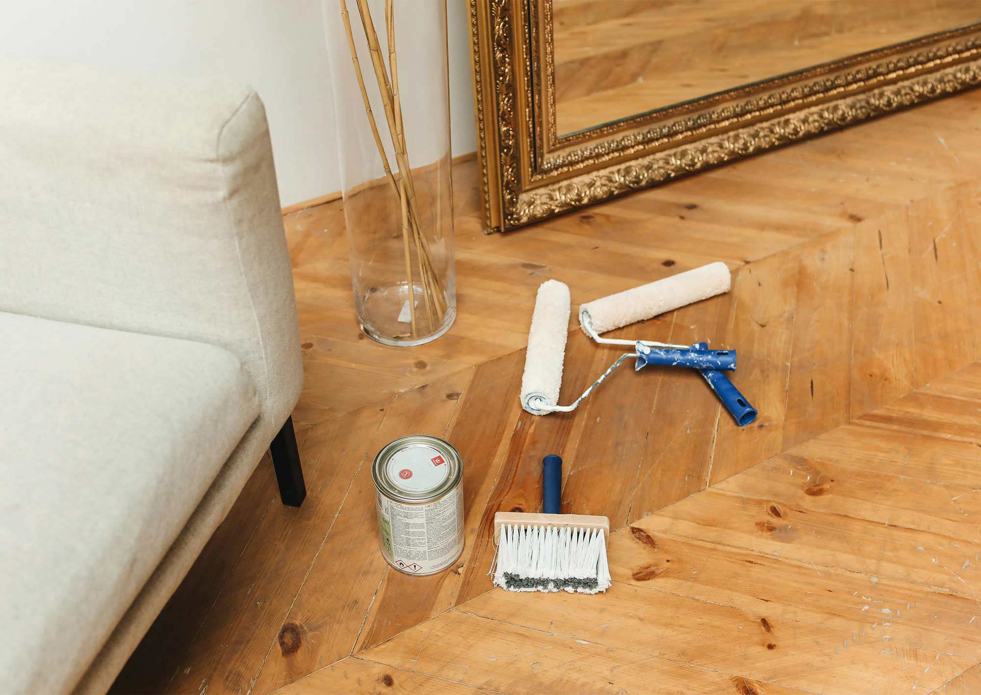 Målartillbehör på golv i gammal lägenhet.