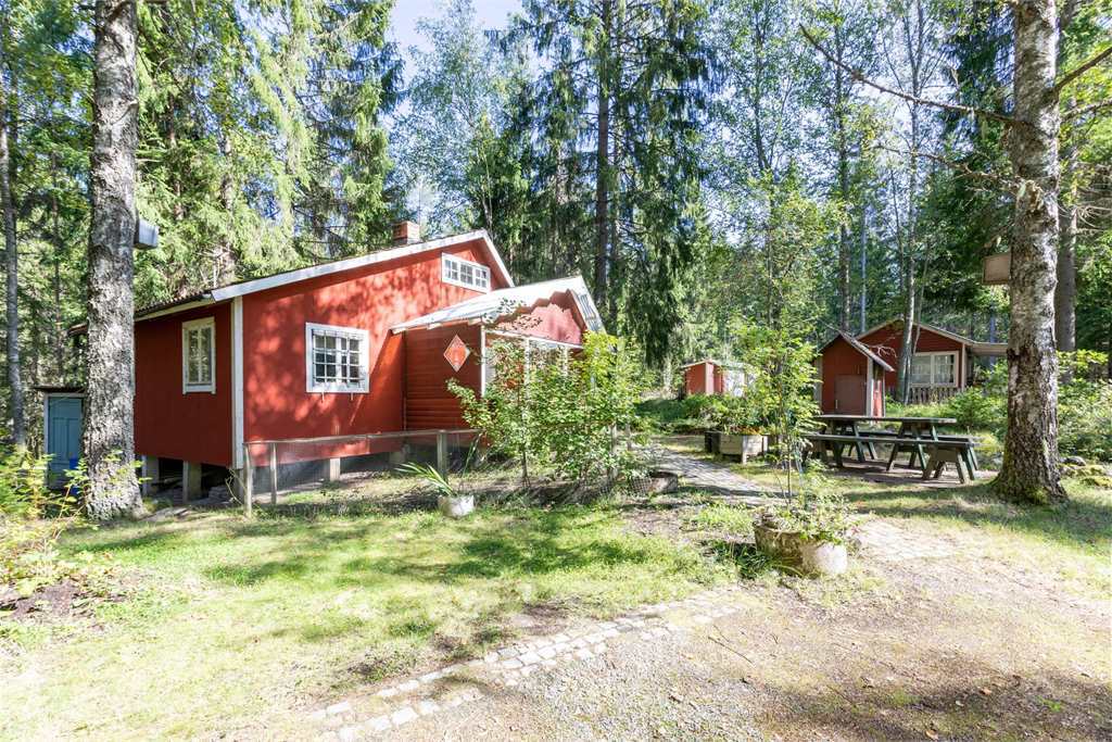 rött fritidshus i skogsdunge