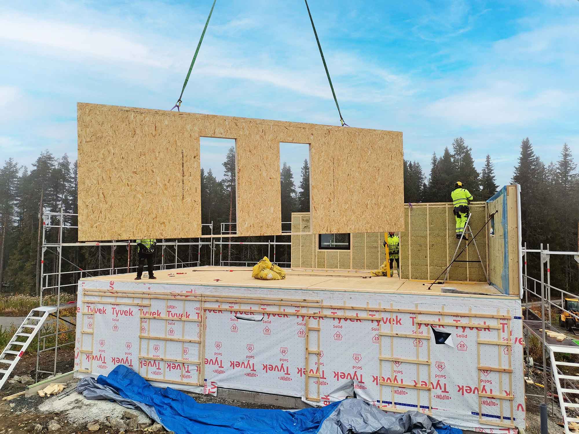 tre personer som bygger hus