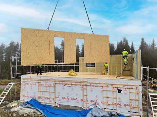 tre personer som bygger hus