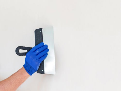 hand som spacklar en vägg