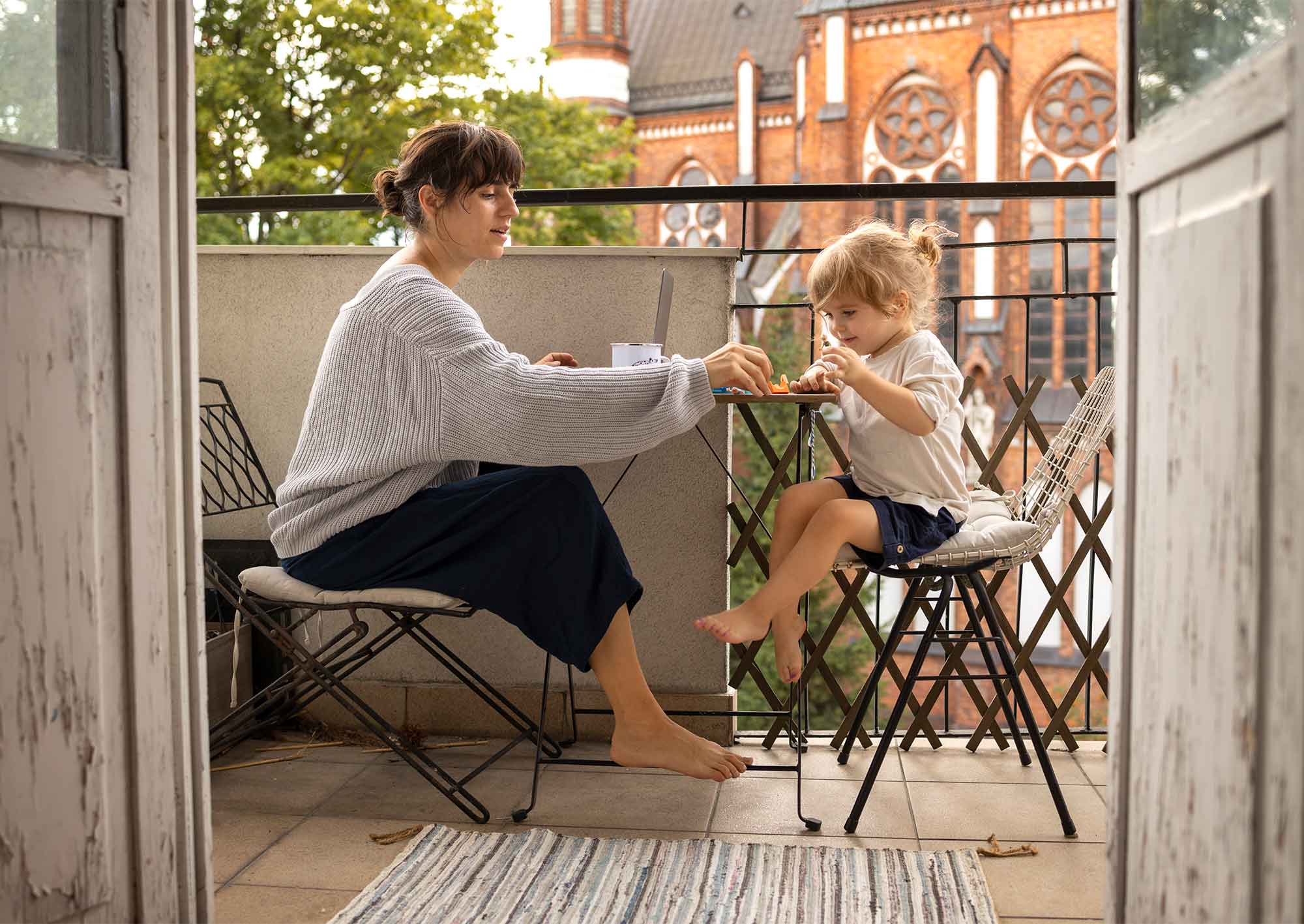 Två personer som fikar på en balkong