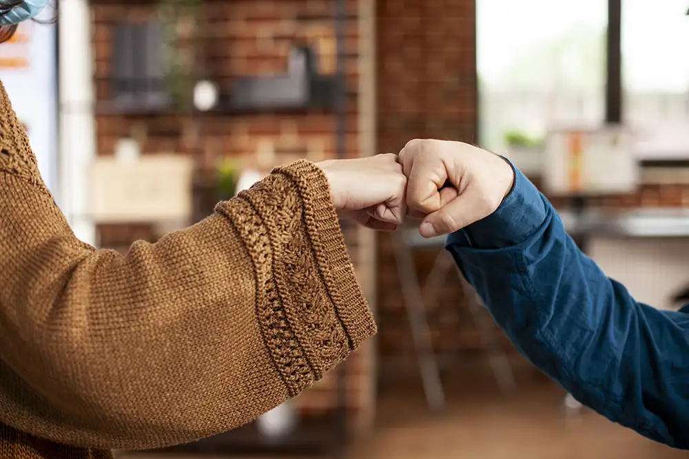 två personer som gör en så kallad fistbump