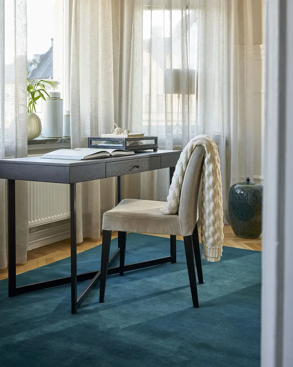 Matta i 2026 års trendfärg, litet bord och en stol som vätter ut mot fönstret