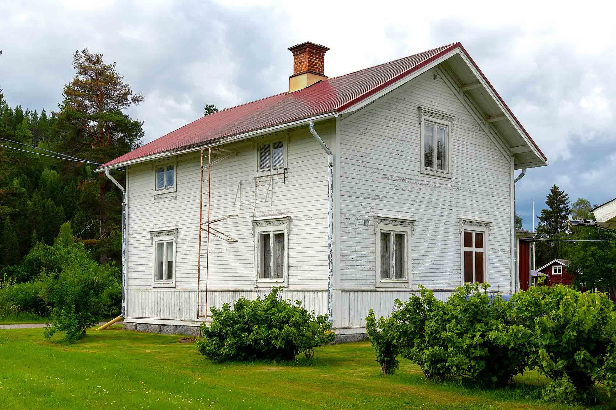 Vitt hus med visst renoveringsbehov