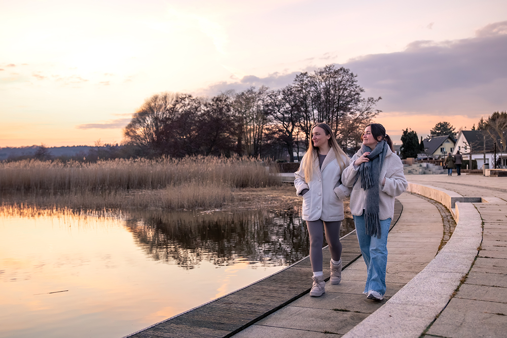 två tjejer som gå längst vattnet