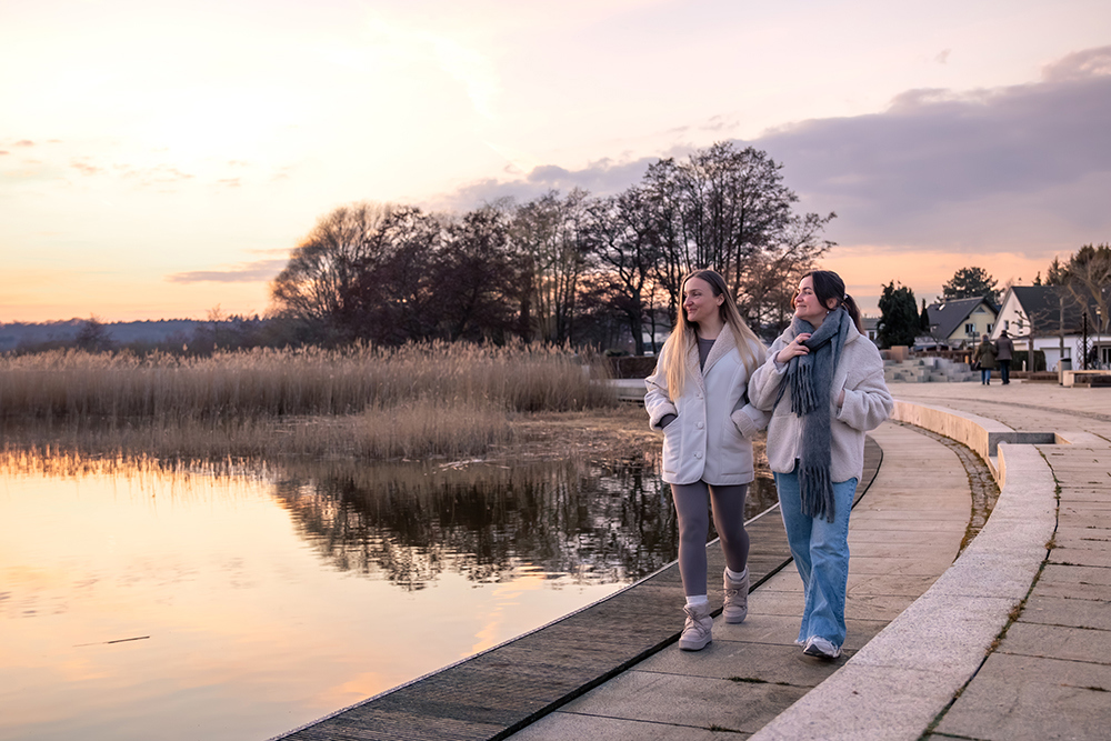 två tjejer som gå längst vattnet