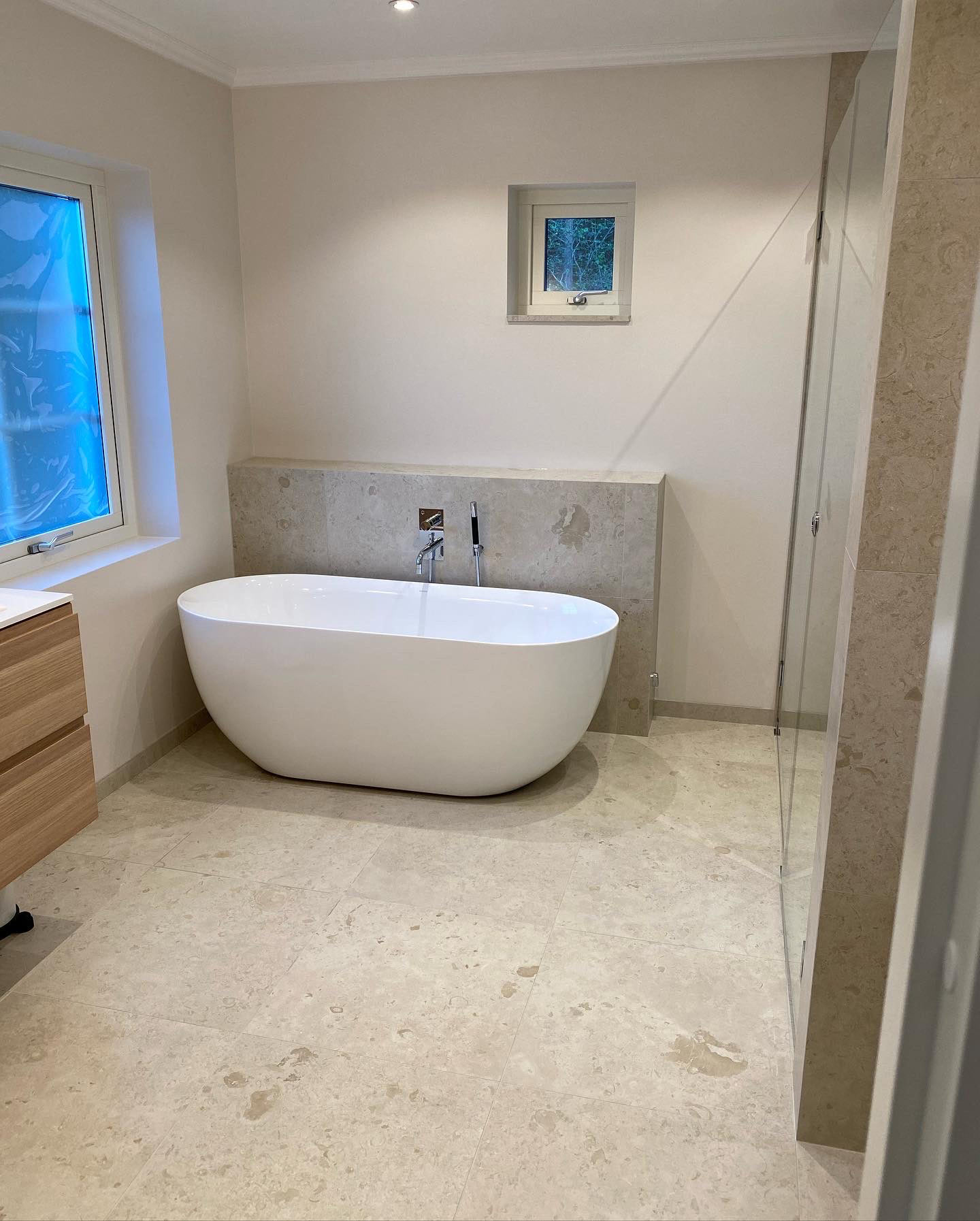 badrum med vitt badkar, fönster, beiget badrum