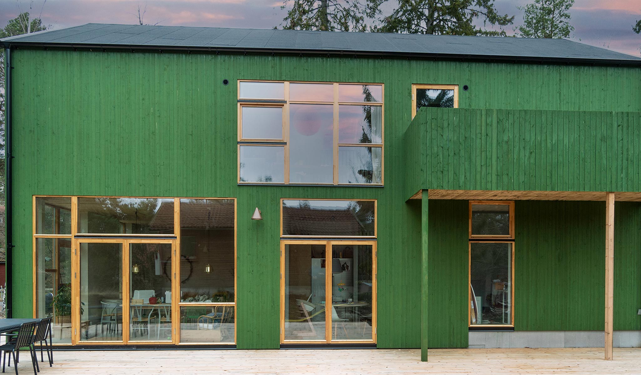 Grönmålat hus med veranda och balkong