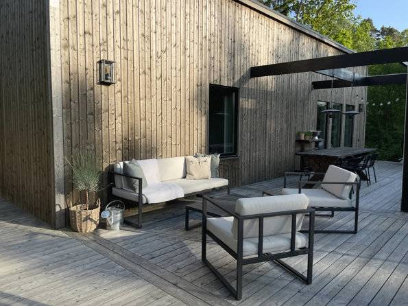 Altan med soffgrupp utanför lösvirkeshus