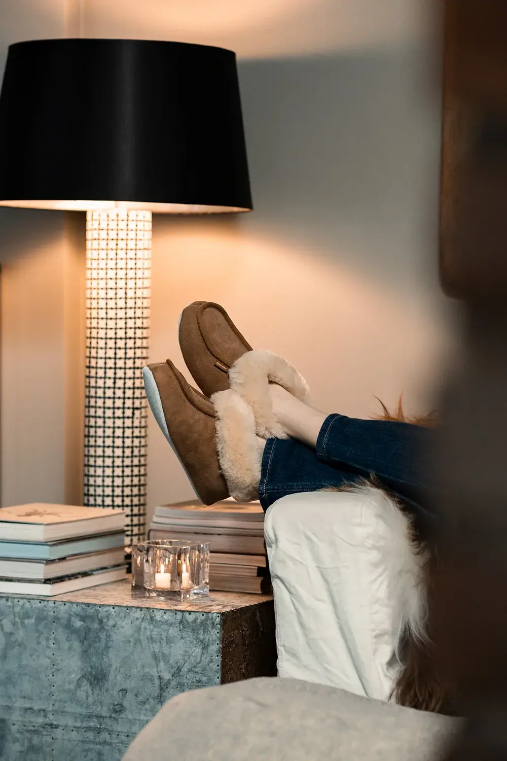 person som sitter med fötterna på bordet med tofflor på