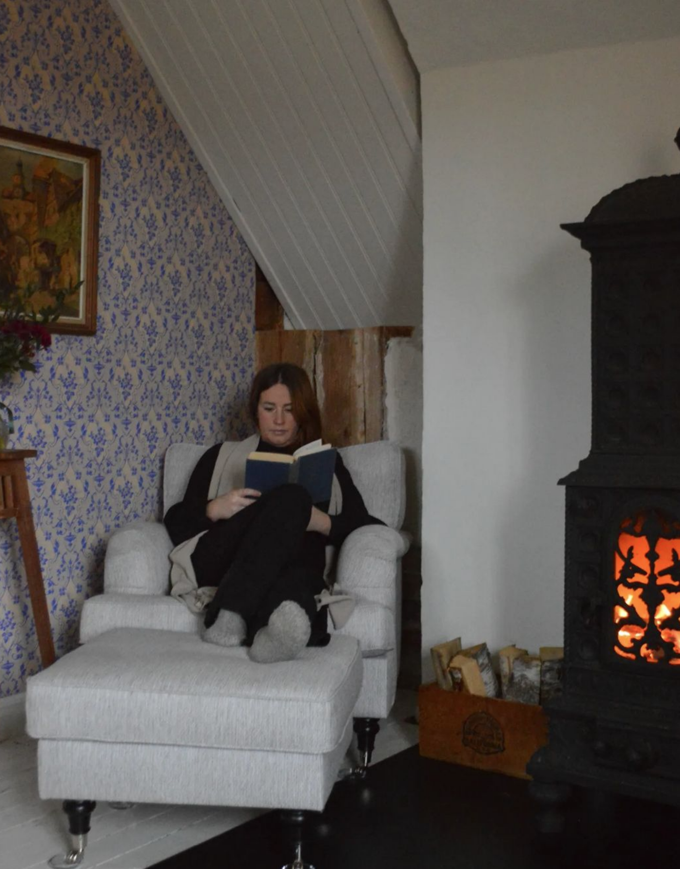 Kvinna med bok som sitter i en fotölj