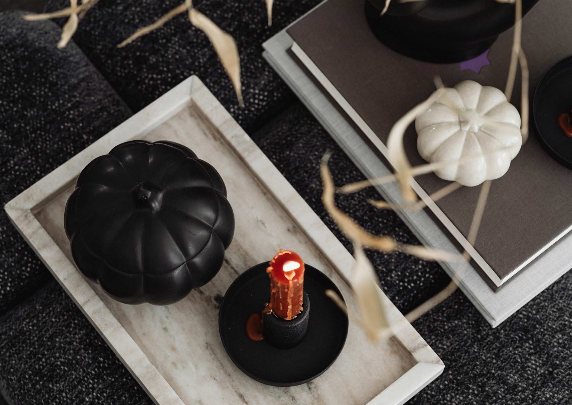 Rött ljus och svart pumpa på ett fat