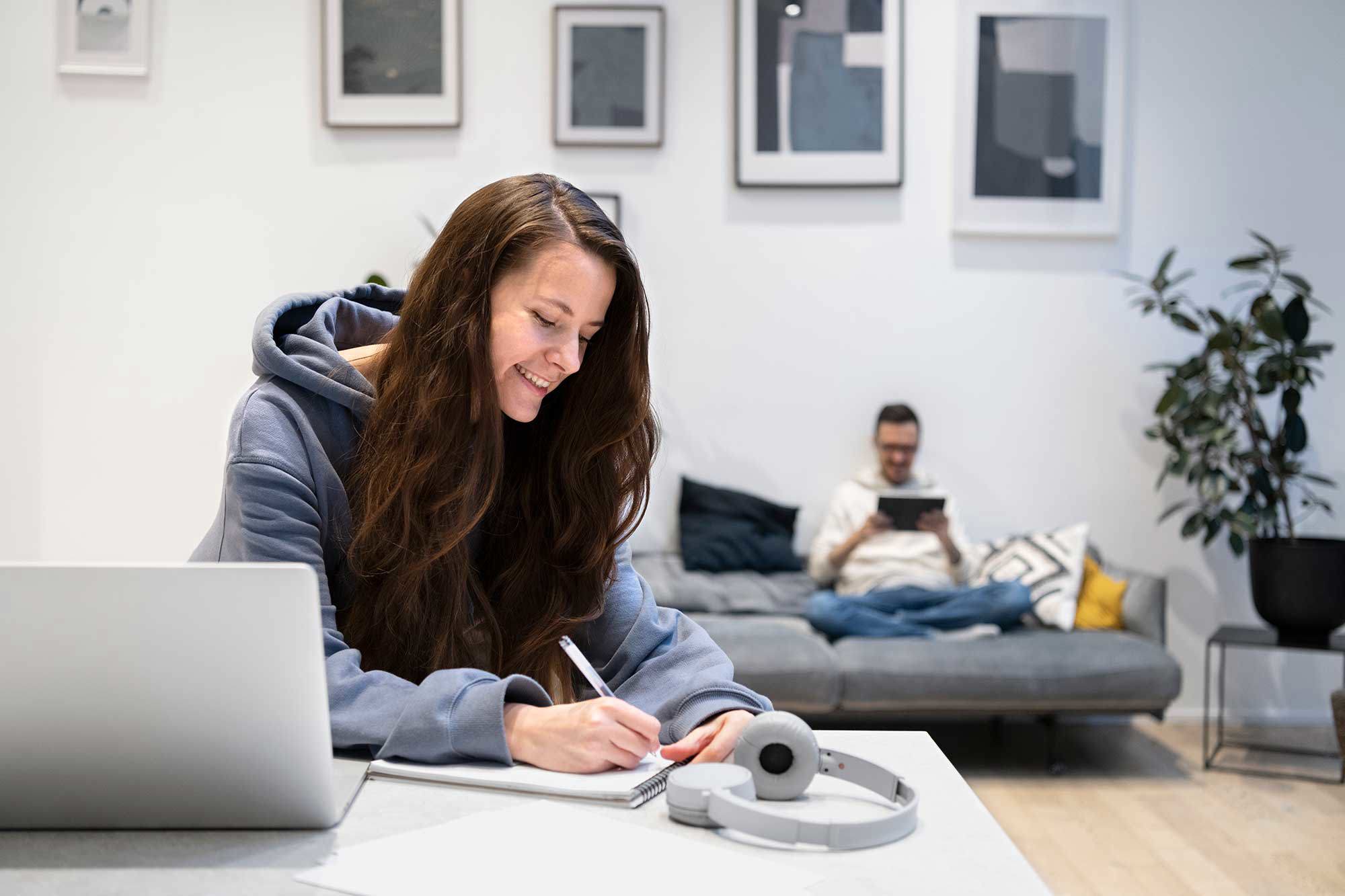 Par som sitter i en studentlägenhet och studerar