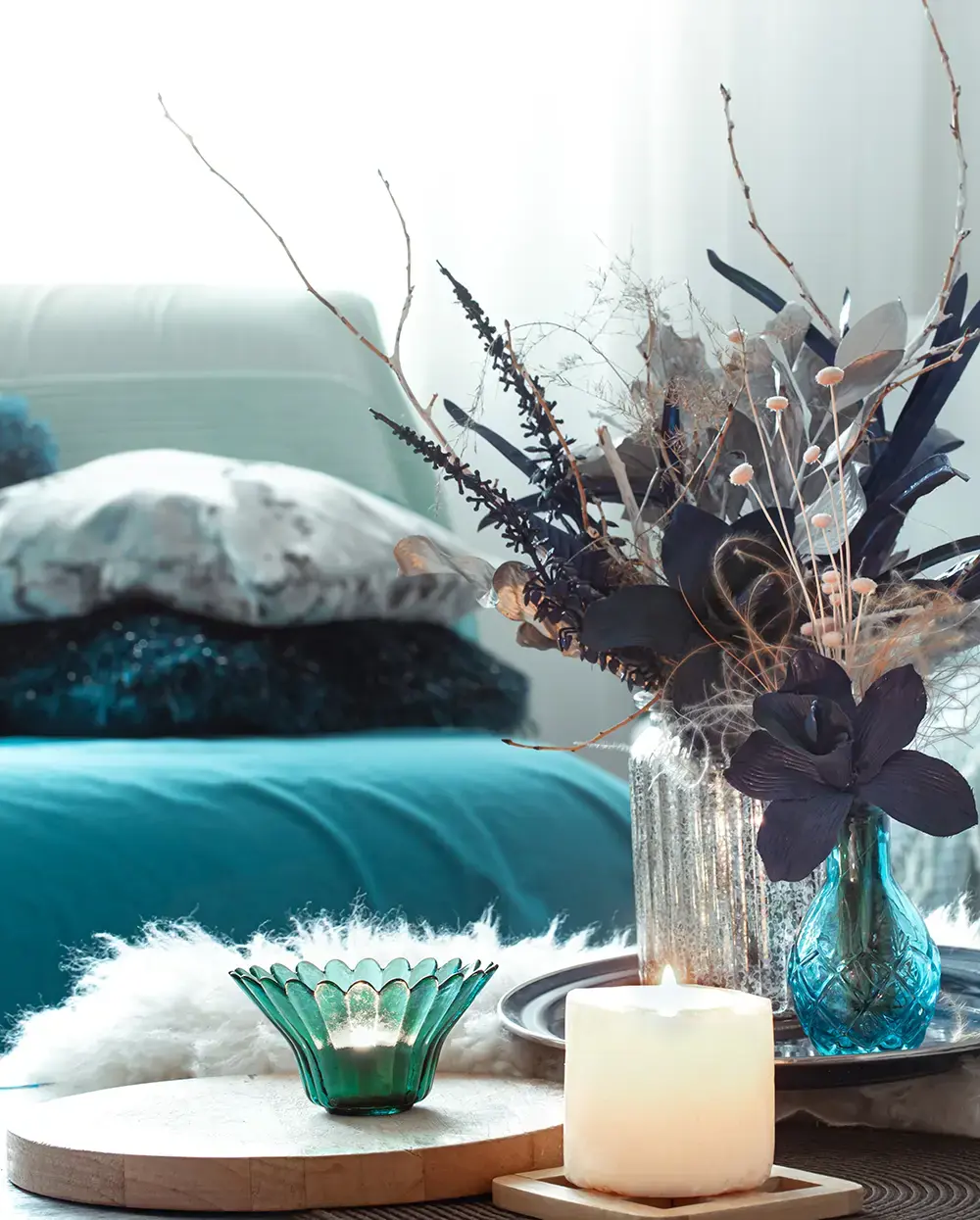 Inredningsdetaljer i transformation teal, soffa, blomma och ljus