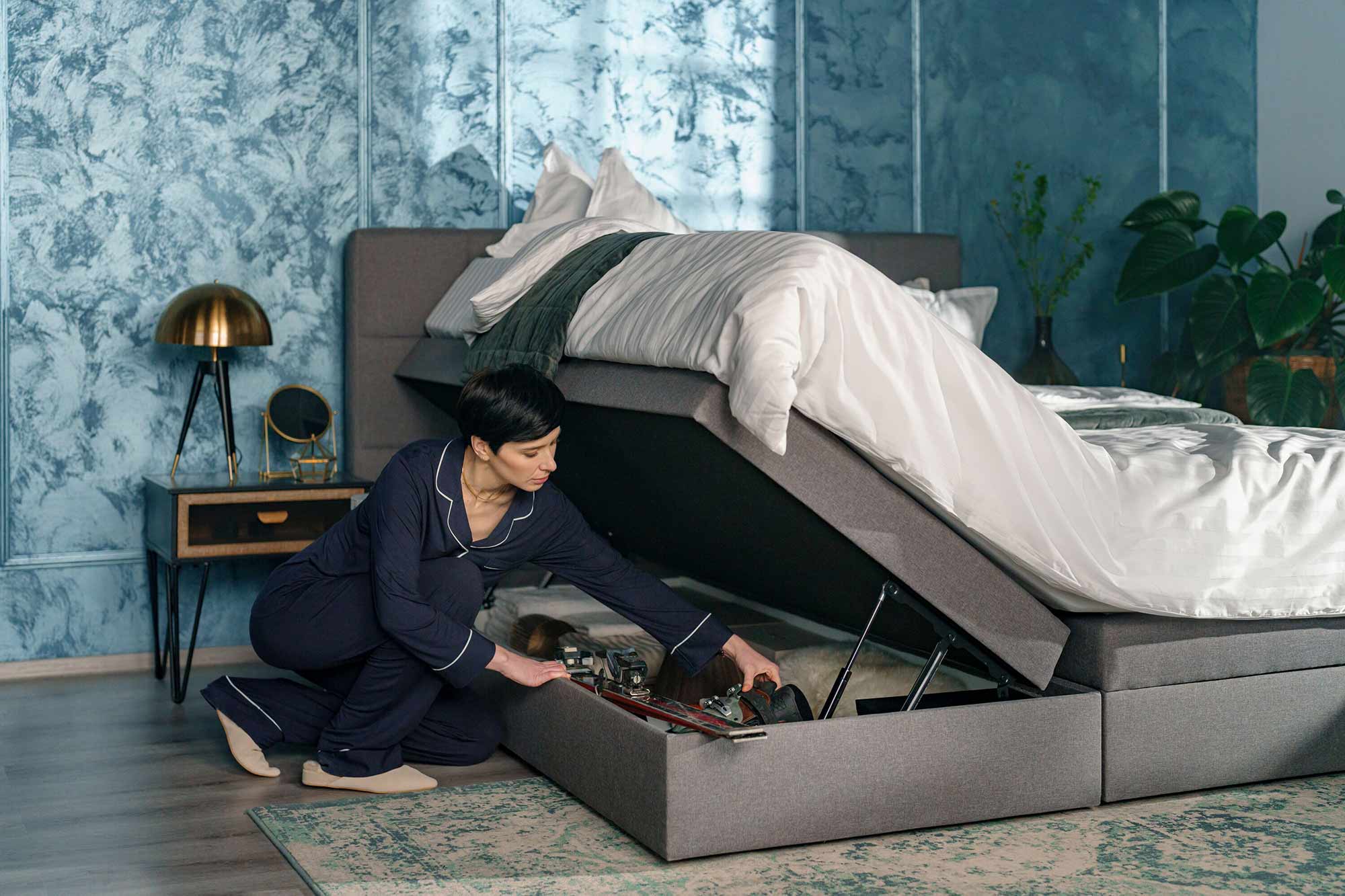 dubbelsäng med förvaring under, kvinna som öppnat förvaringen under sängen