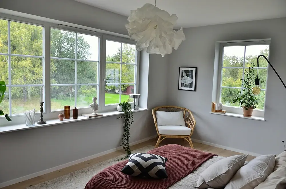 sovrum med fönster som vätter ut mot en trädgård