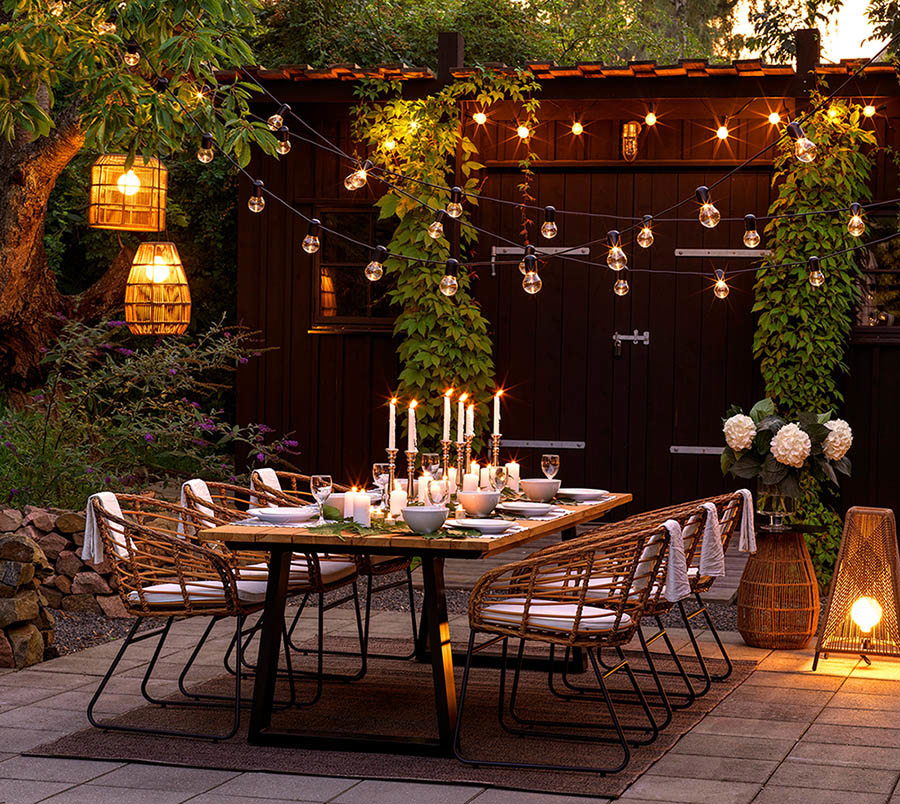 Dekorerad uteplats med belysning över matgrupp